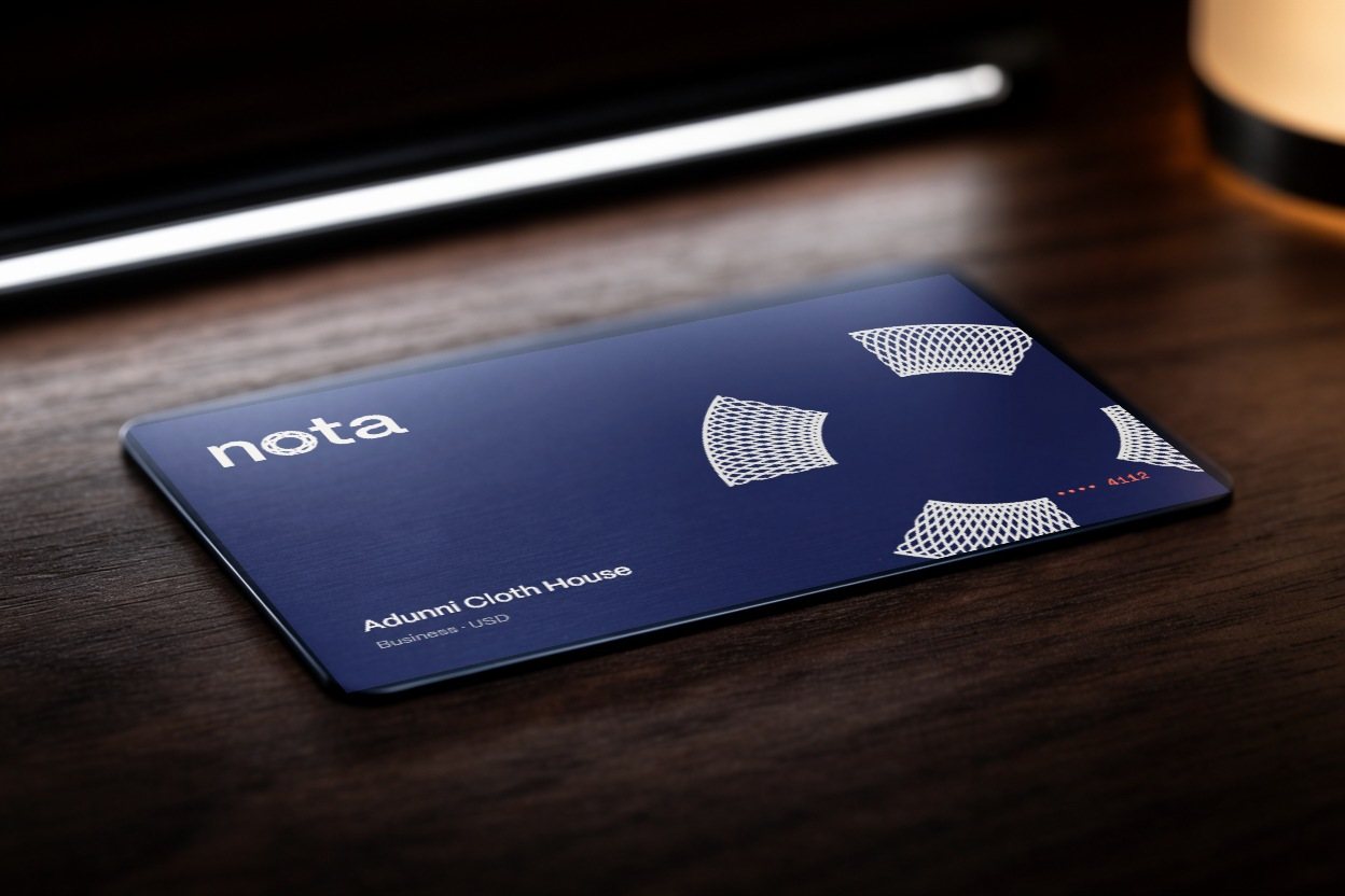 A navy steel nota card on a walnut desk, printed with only the sender's half of the ring.
