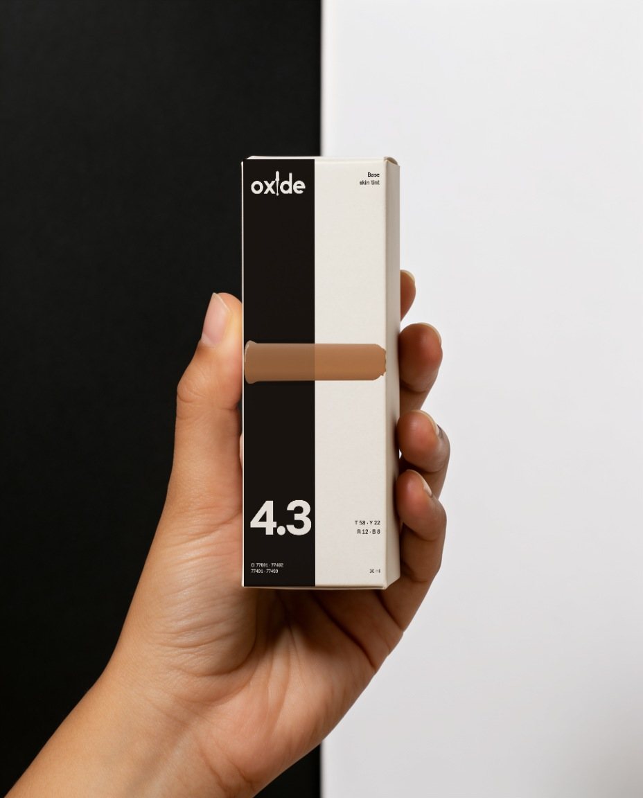 A hand holding the Base 4.3 carton against a black and white backdrop