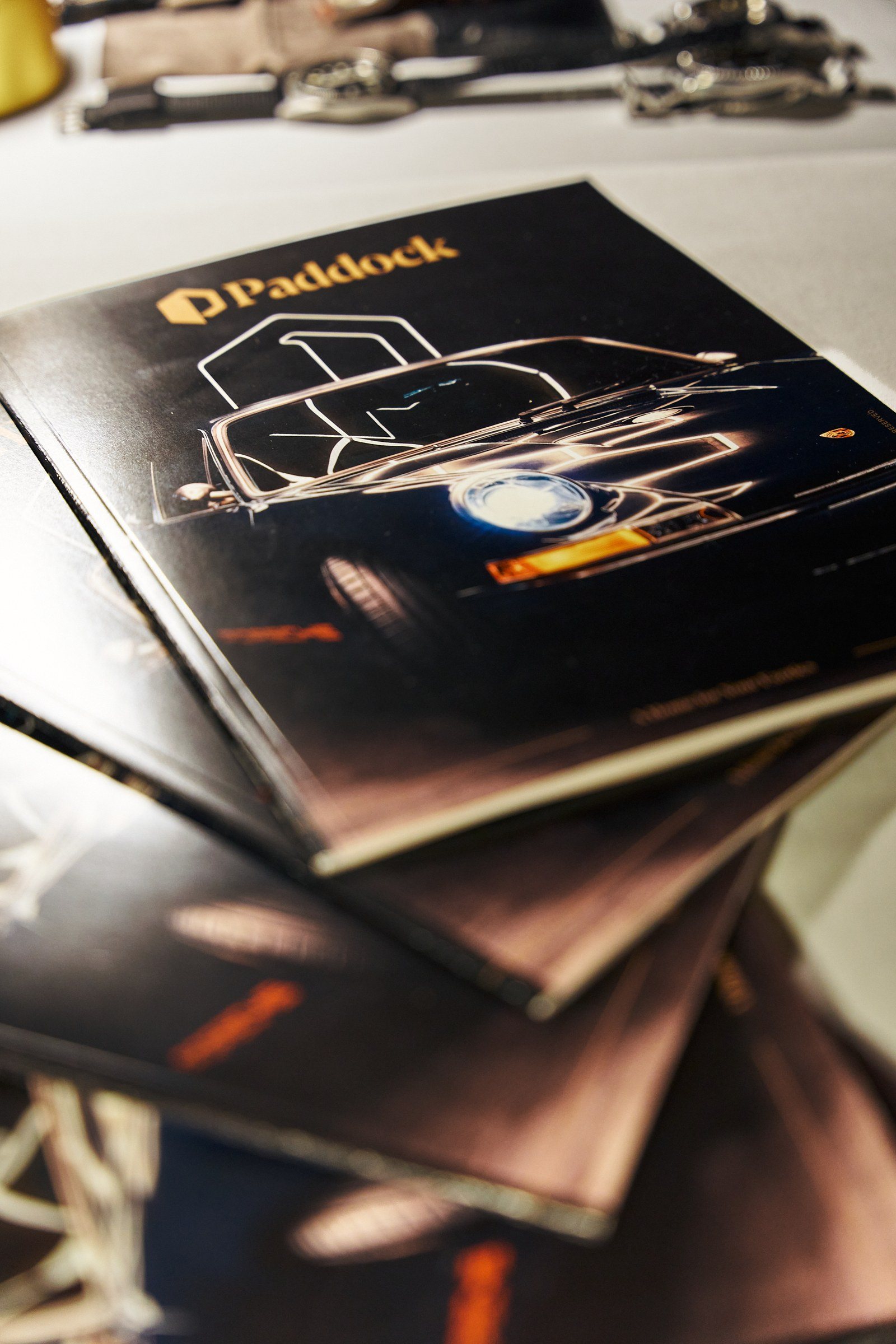 A printed Paddock booklet with a line drawing of a car, on the table.
