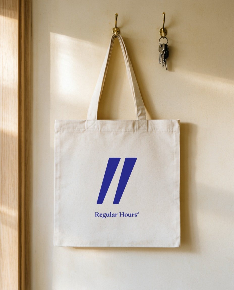 A canvas tote printed with the ditto and wordmark, on a hook beside keys